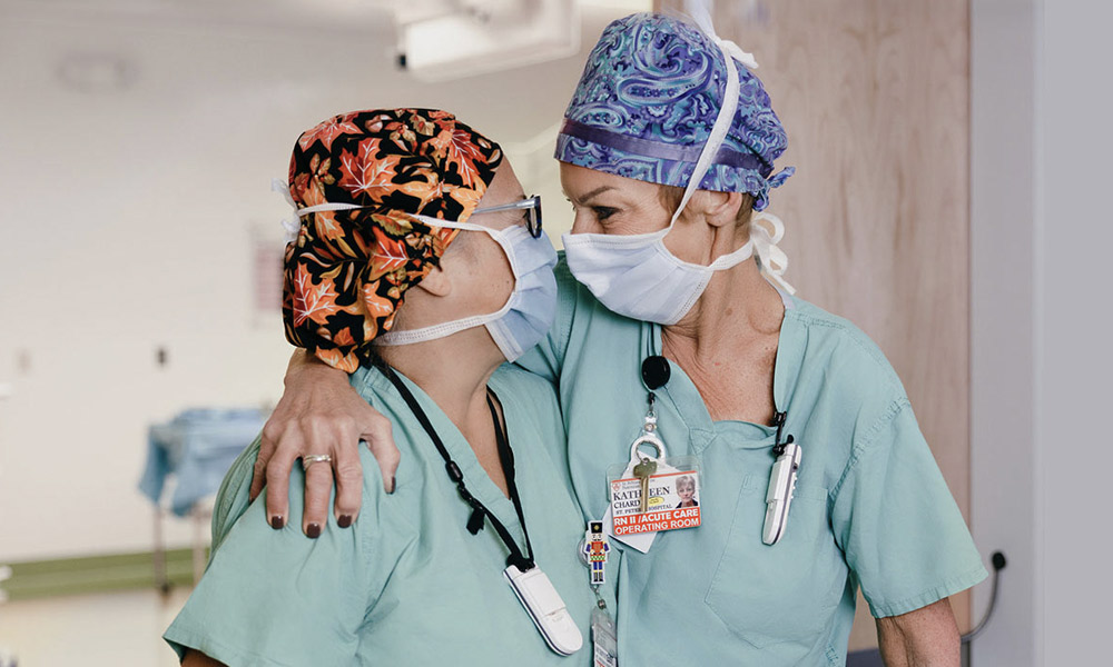 Two nurses embrace.